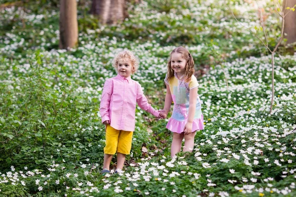 Crianças no parque de primavera com flores — Fotografia de Stock