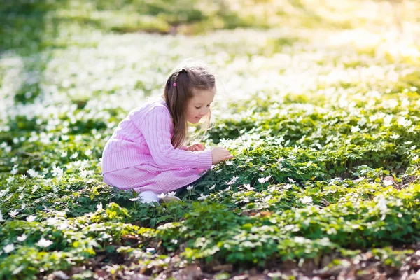 Kind in voorjaar park met bloemen — Stockfoto