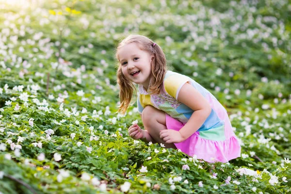 Kind in voorjaar park met bloemen — Stockfoto