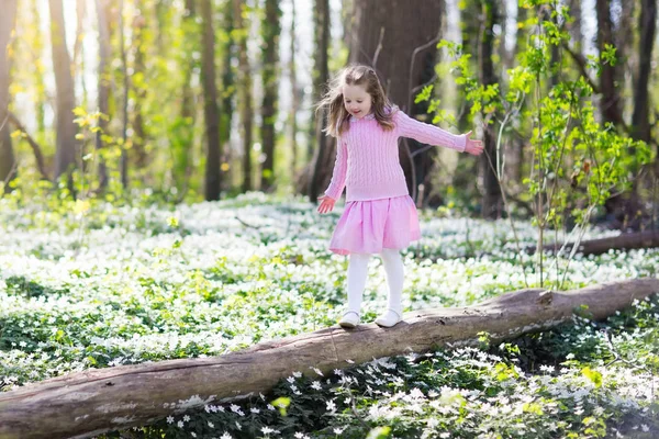 Kind in voorjaar park met bloemen — Stockfoto