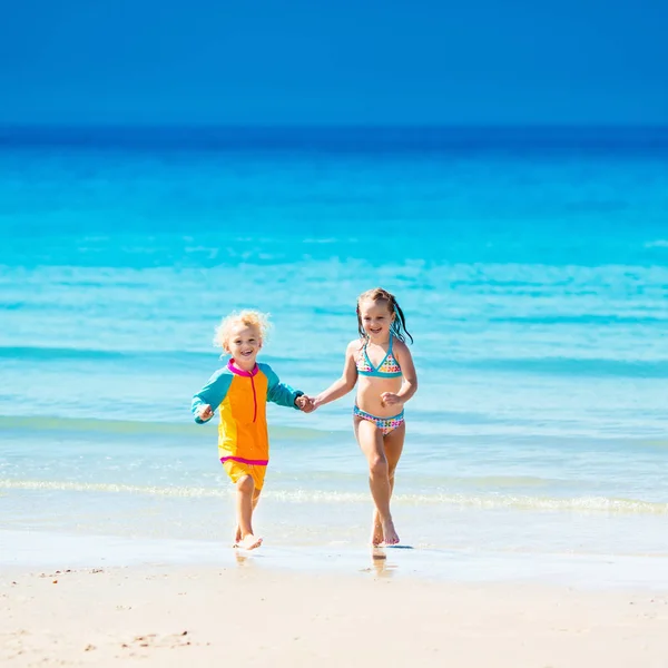 Los niños corren y juegan en la playa tropical —  Fotos de Stock
