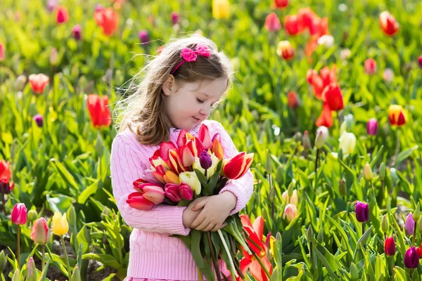 Niña en jardín de flores de tulipán — Foto de Stock