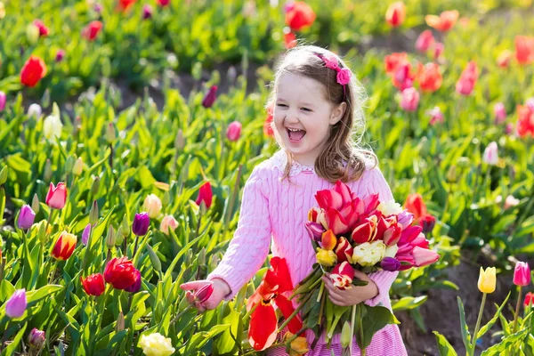 Niña en jardín de flores de tulipán —  Fotos de Stock