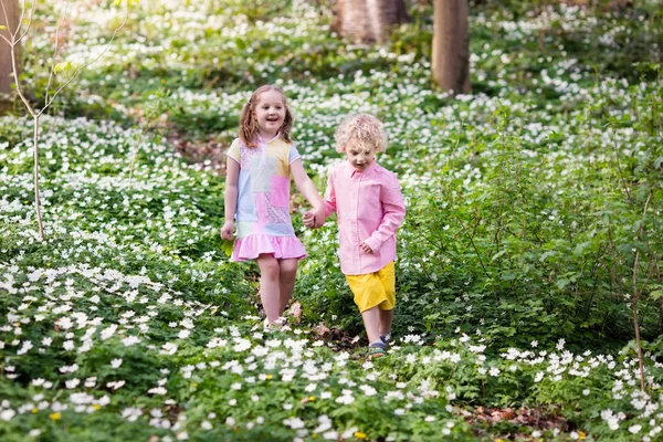 Anak-anak di taman musim semi dengan bunga — Stok Foto