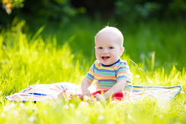 Baby boy with apple on family garden picnic — Stock Photo, Image