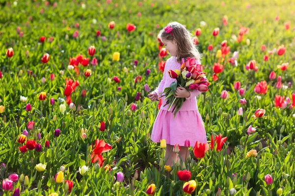 Klein meisje in tulip bloementuin — Stockfoto