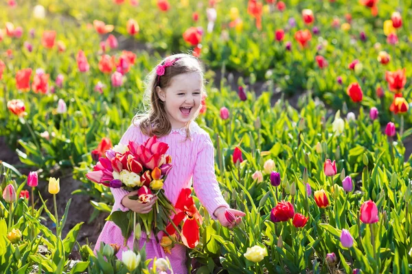 Klein meisje in tulip bloementuin — Stockfoto