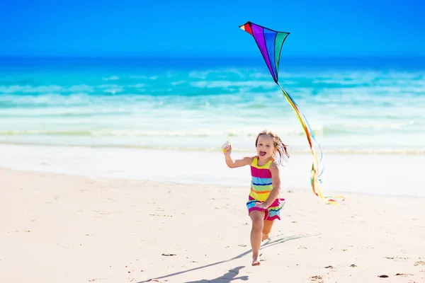 Child flying kite on tropical beach — Stock Photo, Image