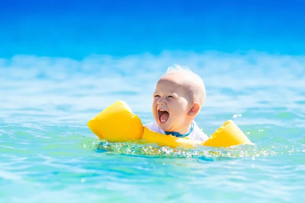 Baby schwimmt im Ozeanwasser am tropischen Strand — Stockfoto