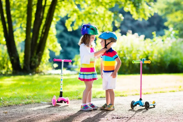 夏の公園でスクーターに乗る子供たち. — ストック写真