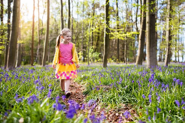 Kind mit Blauglockenblumen im Frühlingswald — Stockfoto