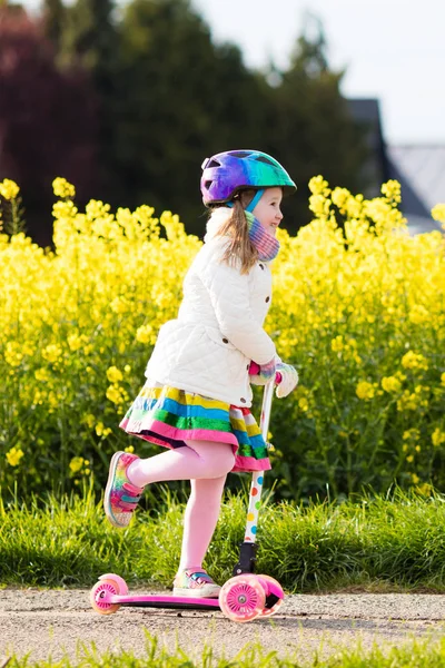 Barn ridning schooter på väg till skolan — Stockfoto