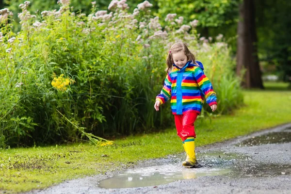 Kinderen spelen in de regen en plas in de herfst — Stockfoto