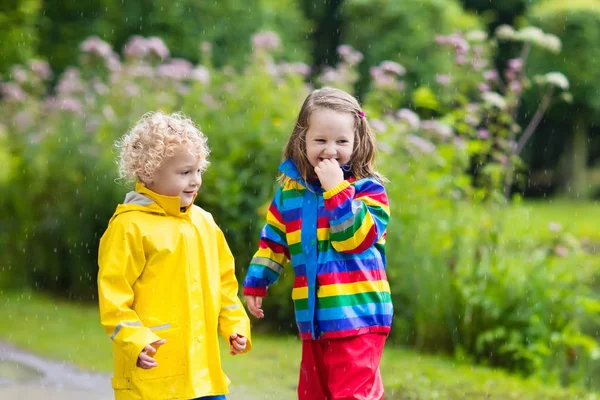 Kinderen spelen in de regen en plas in de herfst — Stockfoto