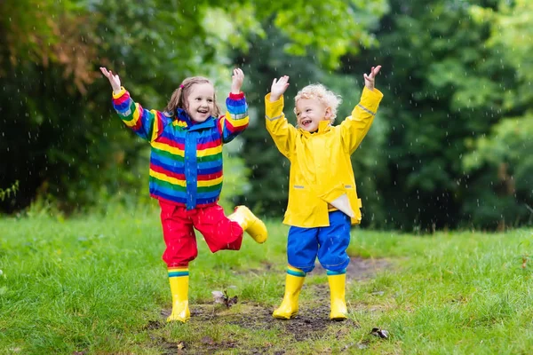 Les enfants jouent sous la pluie et la flaque d'eau en automne — Photo