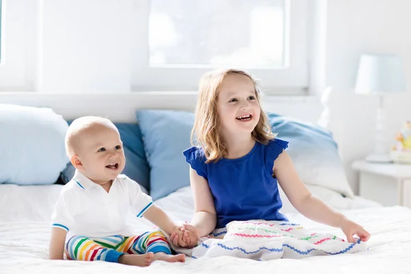 Дети играют на кровати родителей — стоковое фото