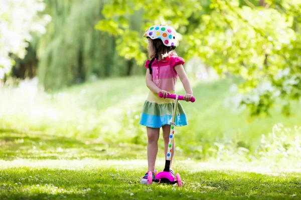 Menina montando uma scooter colorido — Fotografia de Stock
