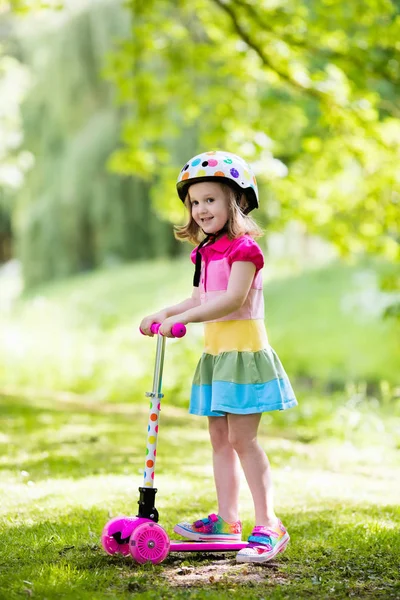 Маленькая девочка на красочном скутере — стоковое фото
