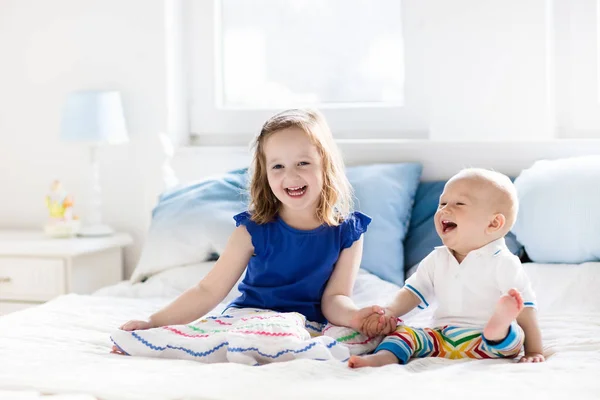 Niños jugando en la cama de los padres — Foto de Stock