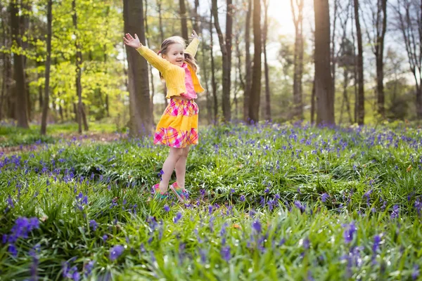Criança com flores de sino azul na floresta de primavera — Fotografia de Stock