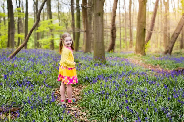 Child with bluebell flowers in spring forest — Stock Photo, Image