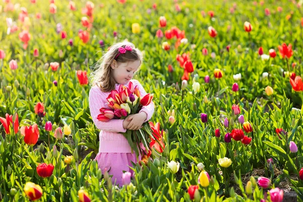 Niña en jardín de flores de tulipán —  Fotos de Stock