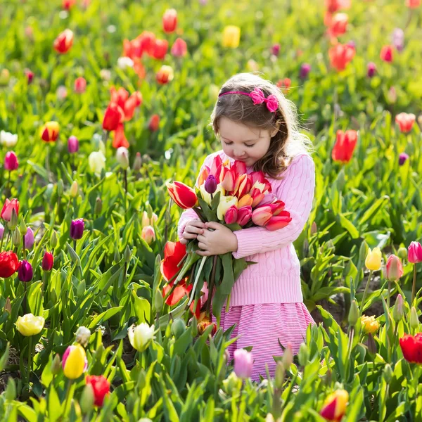 Klein meisje in tulip bloementuin — Stockfoto