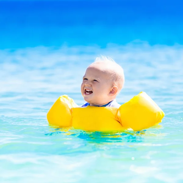 Baby bada i havsvatten på tropical beach — Stockfoto