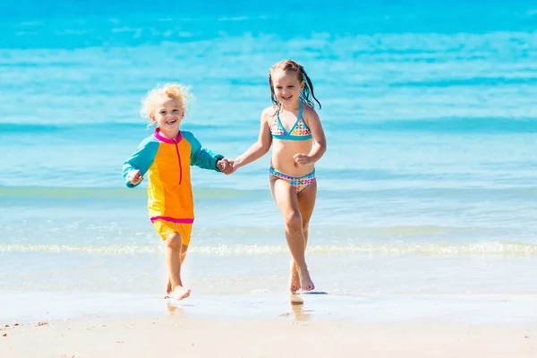 Kinderen rennen en spelen op tropisch strand — Stockfoto