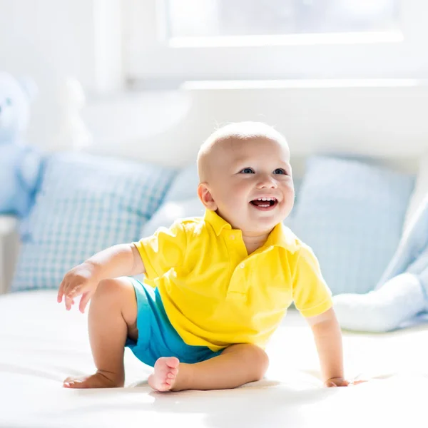 日当たりの良い保育園でベッドで遊ぶ男の子の赤ちゃん — ストック写真