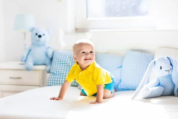 Bambino che gioca sul letto in vivaio soleggiato — Foto Stock