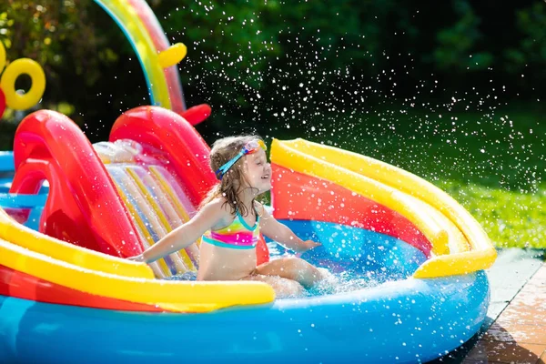 Niño en piscina jardín con tobogán — Foto de Stock