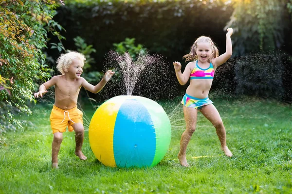 Kids playing with water ball toy sprinkler — Stock Photo, Image