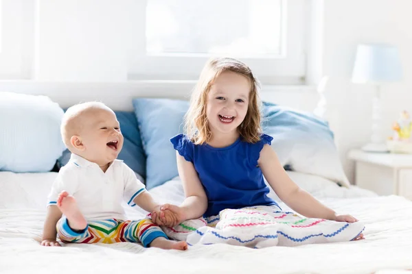 Дети играют на кровати родителей — стоковое фото