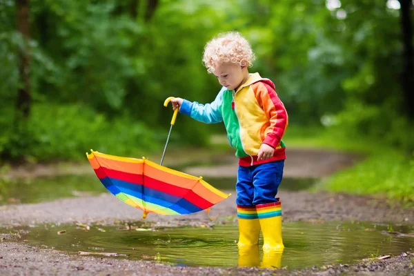 Enfant jouant sous la pluie sous le parapluie — Photo