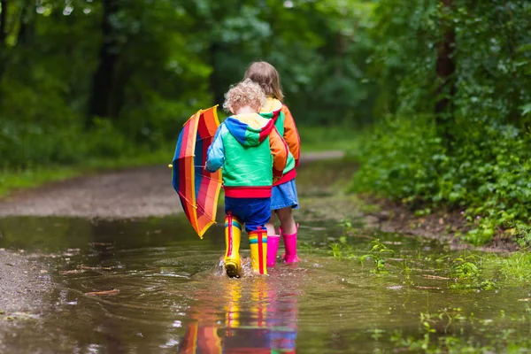 Enfants jouant sous la pluie avec parapluie — Photo