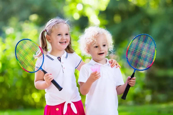 Crianças jogam badminton ou tênis em quadra ao ar livre — Fotografia de Stock