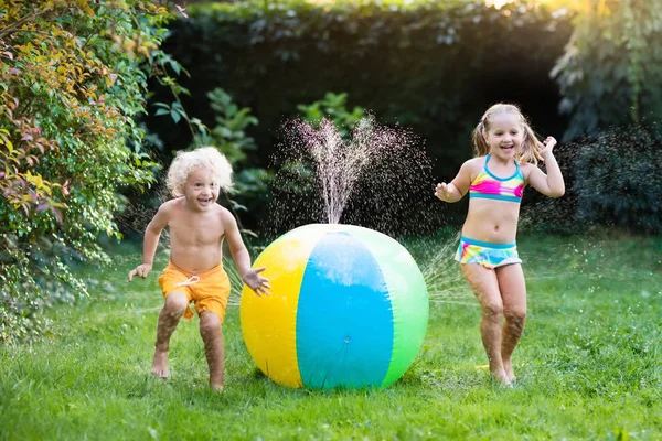 Bambini che giocano con spruzzatore giocattolo palla d'acqua — Foto Stock