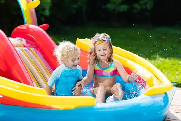 Enfants dans le jardin piscine avec toboggan — Photo