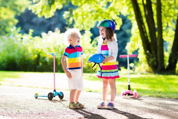 夏の公園でスクーターに乗る子供たち. — ストック写真