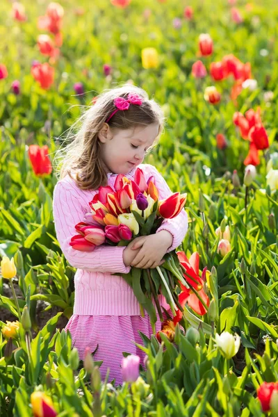 Niña en jardín de flores de tulipán — Foto de Stock