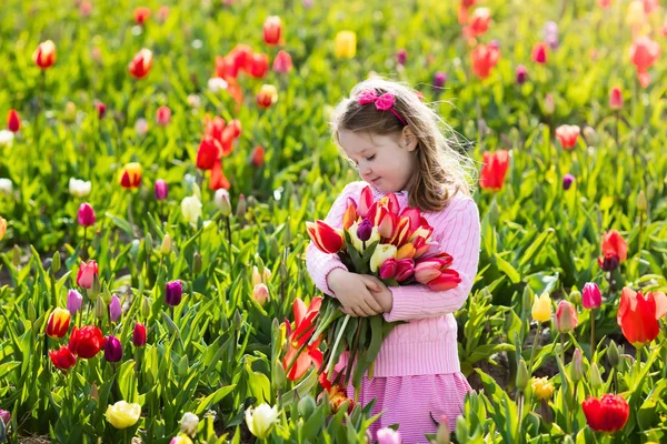 Liten flicka i tulip flower garden — Stockfoto