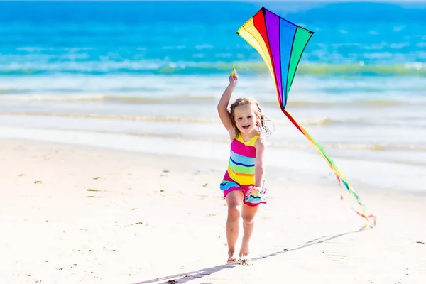 Child flying kite on tropical beach — Stock Photo, Image