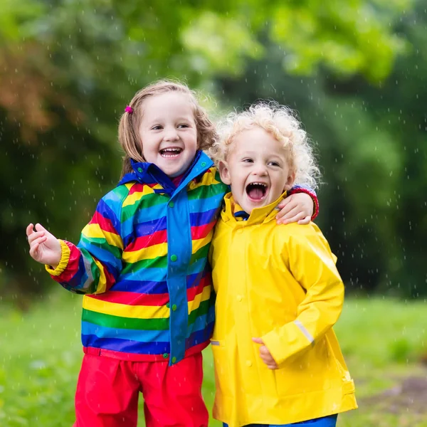 Kids play in rain and puddle in autumn — Stock Photo, Image