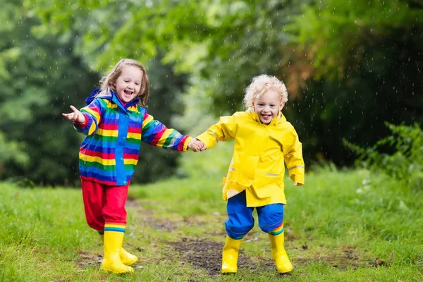 Kinderen spelen in de regen en plas in de herfst — Stockfoto