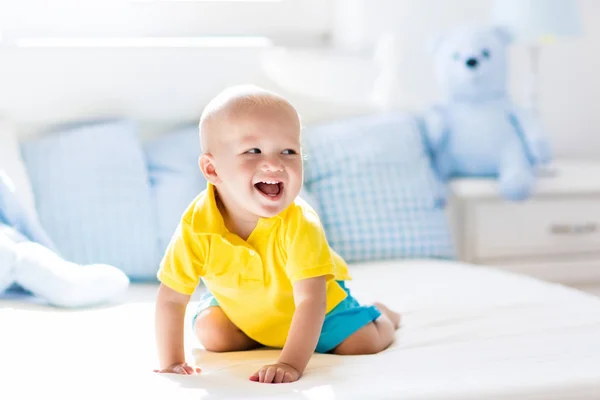 日当たりの良い保育園でベッドで遊ぶ男の子の赤ちゃん — ストック写真