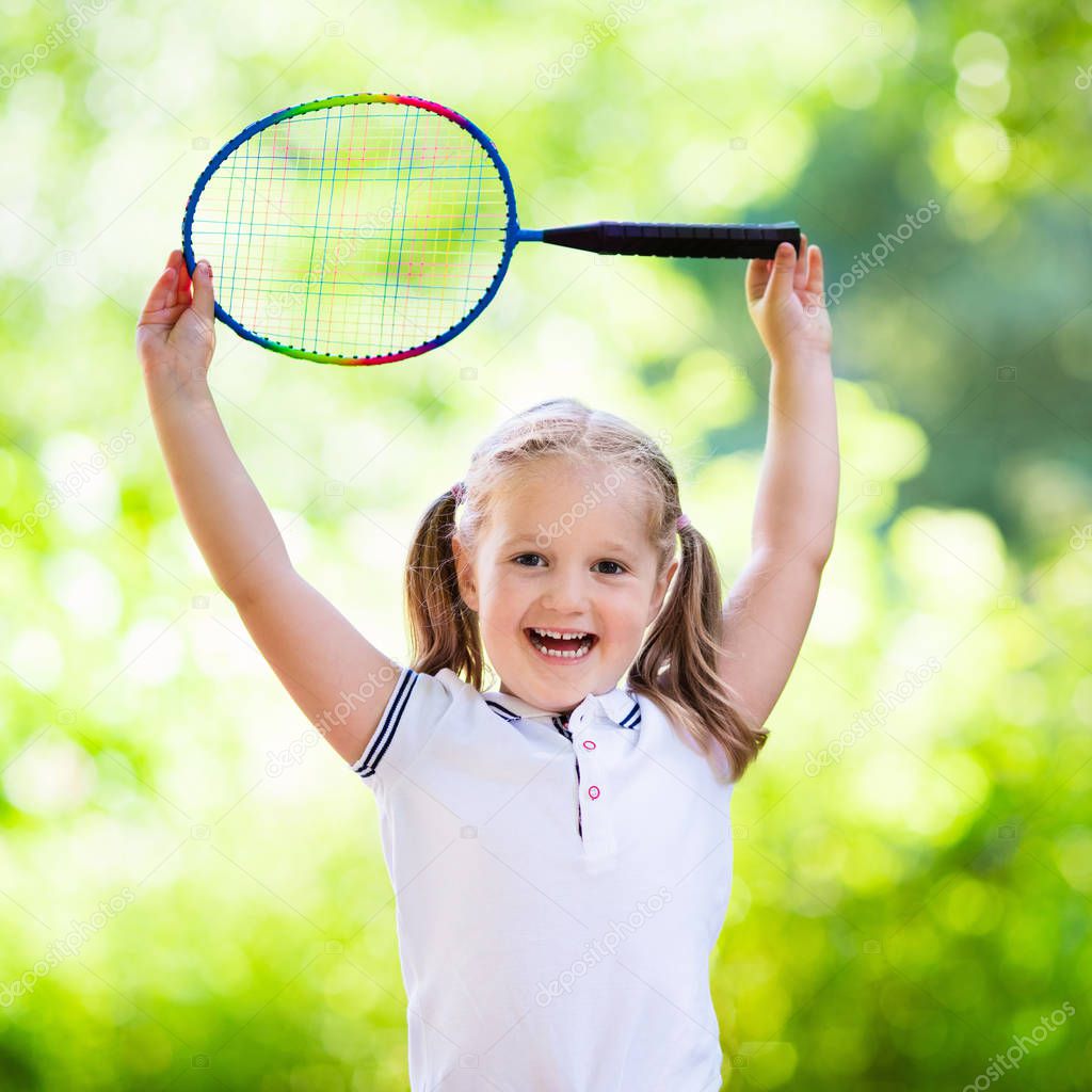 Child playing badminton or tennis outdoor in summer