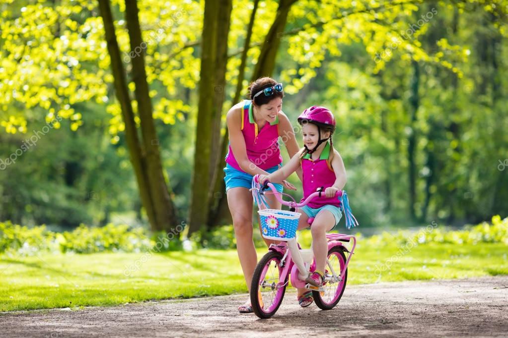 Mother teaching child to ride a bike — Stock Photo