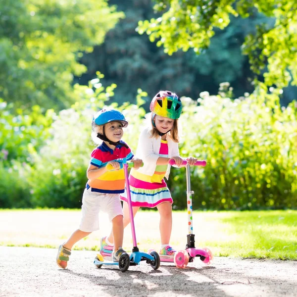 Kids riding scooter in summer park. — Stock Photo, Image