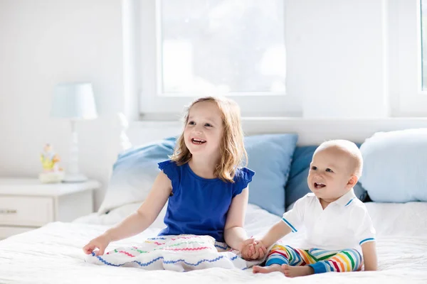 Kinder spielen auf dem Bett der Eltern — Stockfoto